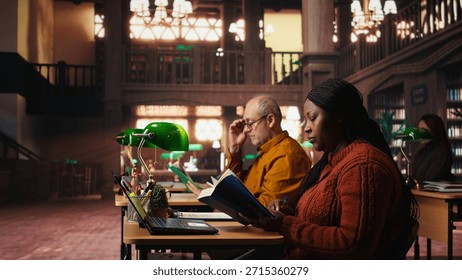 Graduate students researching in a quiet library